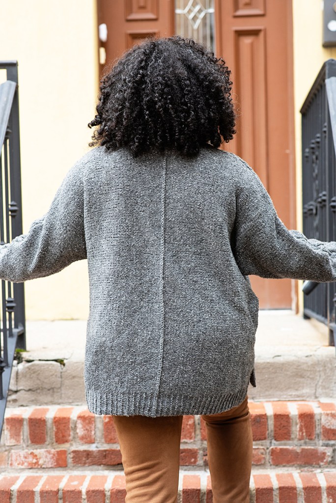 Back view of a woman wearing a hand knit pullover.
